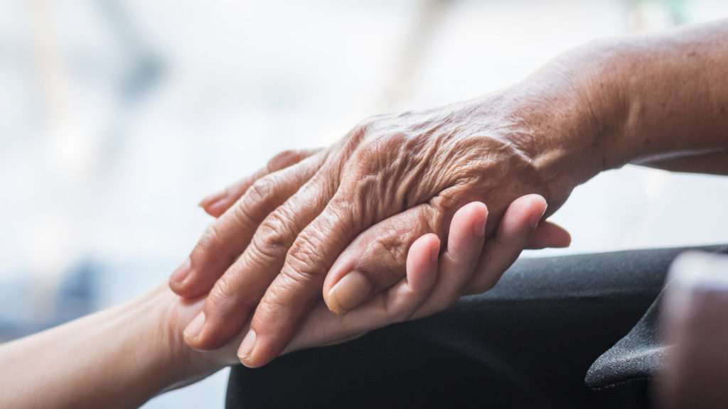 Elderly hand holding adult hand